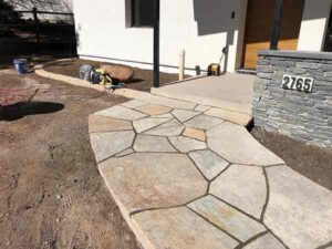 Carefully mosaiced Colorado Buff Sandstone make for an attractive entryway and sidewalk for this Boulder home.