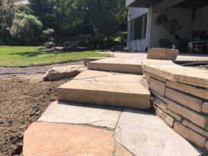 Small stepper adjoin the walkway and retaining wall to the entryway using Colorado Buff sandstone.