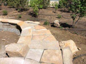 A Colorado Buff retaining wall and sidewalk separates lawn and garden at this Niwot, CO, home