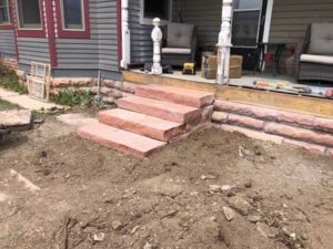 Red strip stone and solid red flagstone step accent this older Longmont home.